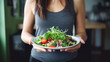 © red_orange_stock - The girl is holding a plate of salad.