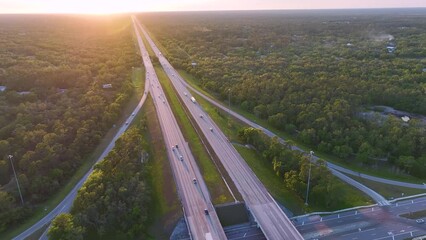 Poster - View from above of busy american highway crossroads with fast moving traffic in green Florida area in the evening. Interstate transportation concept