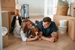 © standret - Happy young couple with dog are moving to new home. On the floor