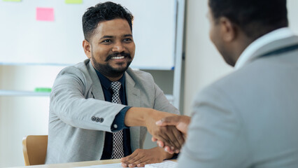 Handshake of businessman and a partner after success of planning strategy marketing in the office