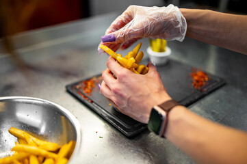 woman chef preparing french fries in restaurant kitchen