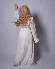 Sticker - Full length portrait of blonde woman  wearing  white historical bridal gown fantasy costume dress. Standing pose, facing backwards walking away from camera, isolated on studio background.