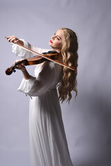 Wall Mural - Close up portrait of beautiful blonde model wearing elegant  white halloween gown, a historical fantasy character.  Holding a violin musical instrument, isolated on studio background.