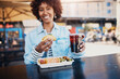 © Flamingo Images - Smiling woman having a drink and eating tacos on a restaurant patio
