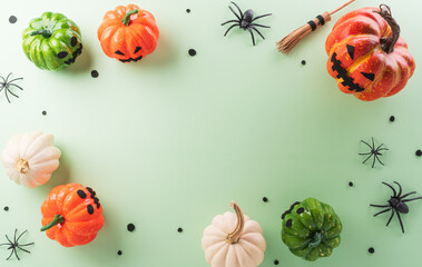 Wall Mural - Halloween decorations made from pumpkin, paper bats, black spider on pastel background