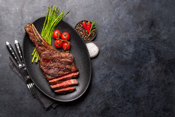 Wall Mural - Medium rare grilled Tomahawk beef steak with asparagus