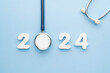 Stethoscope with 2024 number on blue background. Happy New Year for health care and medical banner calendar cover. Creative idea for new trend in medicine treatment and diagnosis concept.