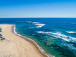 © Austockphoto - Blue green waves in vast ocean washing up to beach in sunlight