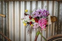 Vintage Bike Leaning Against Shed Wall With Fresh Flowers
