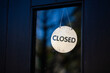 © Austockphoto - Closed sign hanging in glass pane of shop front door