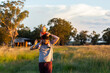© Austockphoto - Baby girl on dads shoulders riding piggyback through farm paddock at sunset