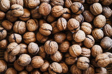 Wall Mural - Organic walnuts on wooden table, autumn harvest time full frame, top view close up