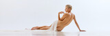 Banner. Rear view. Fit young beautiful naked woman on floor with transparent fabric on light studio background. Femininity. Ad.