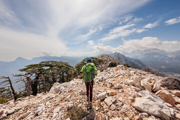 A girl with a backpack on a hike. adventure in the mountains. hiking with a backpack. girl with a backpack in the high mountains. Rock climbing and mountaineering concept.