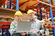 © FotoArtist - Warehouse workers checking the inventory. Products on inventory shelves storage. Worker Doing Inventory in Warehouse. Dispatcher in uniform making inventory in storehouse. supply chain concept