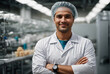 successful food factory man manager in sterile uniform with arms crossed smiling at the camera. hair net