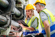 © FotoArtist - Industrial worker indoors in factory. Young technician with orange hard hat. Smart Caucasian factory worker wearing hardhat and working in power plant.