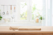 Cutting board on table in blurred kitchen interior with space