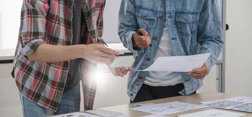 a smart and handsome young asian male website developer is talking and planning a new project with a