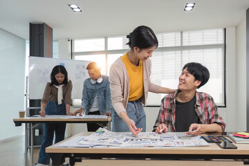 A group of professional Asian UI, UX graphic designers, or developers is in the meeting, brainstorming and planning a new project together.