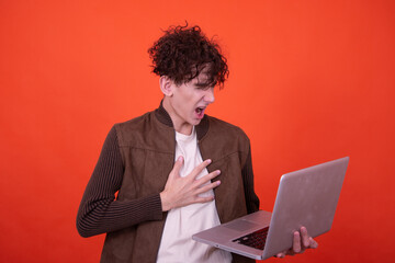 Wall Mural - Study and work. Attractive curly student posing on an orange background.