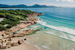 Beach, rocks and transparent ocean with small waves in Brazil. Aerial view of tropical beach in Florianopolis