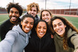 © MVProductions - Happy diverse friends taking selfie on smartphone on sports ground