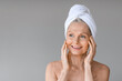 © Prostock-studio - Beauty and skincare. Portrait of beautiful mature woman with towel on head, looking aside at free space and smiling