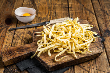 Wall Mural - Cooking raw spaetzle egg noodle. Wooden background. Top view