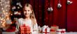 Little girl holding a gift box with Christmas decorations in the background Generative AI