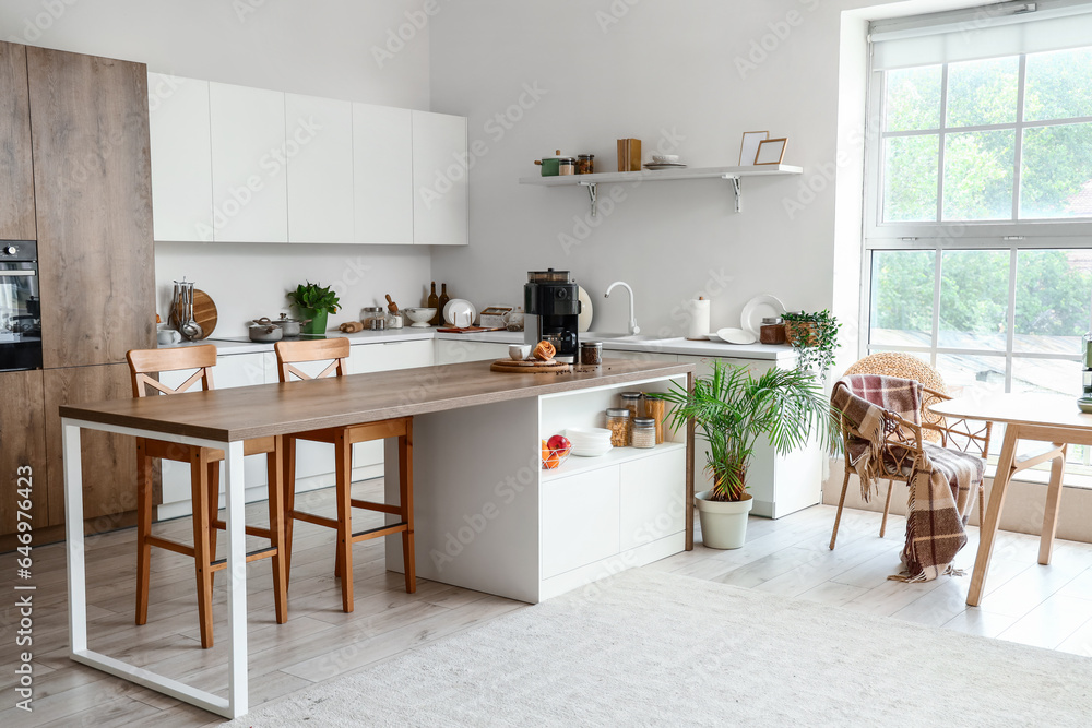Interior of modern kitchen with modern coffee machine on wooden table