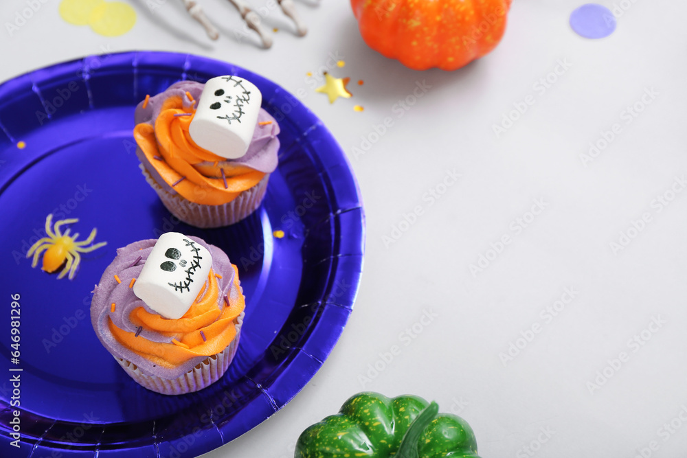 Halloween cupcakes decorated with spooky marshmallows on grey table, closeup