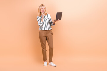 Sticker - Full length photo of cute clever woman dressed striped shirt typing emails modern device empty space isolated beige color background