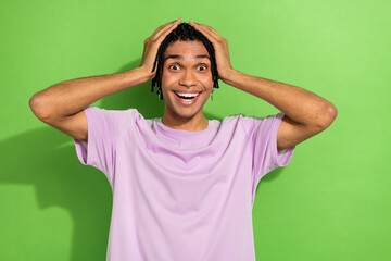 Sticker - Portrait of impressed cheerful young man arms touch head beaming smile unbelievable news isolated on green color background