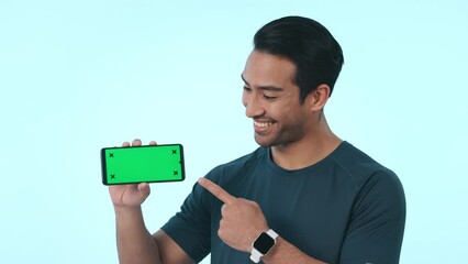 Wall Mural - Happy asian man, phone and pointing to green screen mockup in advertising against a studio background. Portrait of male person smile and showing mobile smartphone display or app with tracking markers