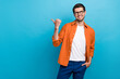 © deagreez - Photo of positive sale manager man toothy smile direct thumb finger empty space isolated on blue color background