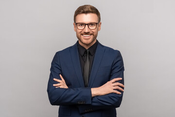 portrait of happy successful confident businessman in suit with crossed arms on chest smiling lookin