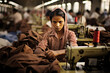 Portrait of young girl sewing clothing in Multinacional Factory , precarious jobs, poor work condition, exploitation and fast fashion concept
