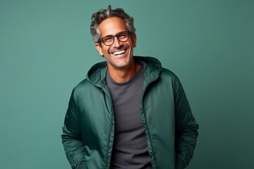 Wall Mural - Portrait of handsome middle aged man in green jacket and eyeglasses smiling at camera.