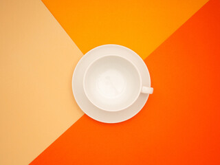An empty white coffee cup over three colorful paper backgrounds.