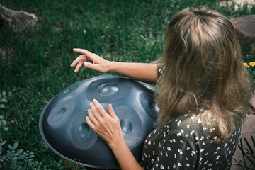 a woman plays on handpan or hang