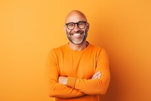 Portrait Of Happy Mature Man In Orange Sweater And Eyeglasses On Orange Background