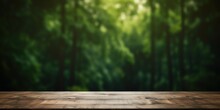 Empty Wood Table Top With On Blurred Dark Green Fores Background.