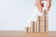 © Ratana21 - For business growth success process concept. Hand arranging wood block stacking as step stairs with white increasing arrow