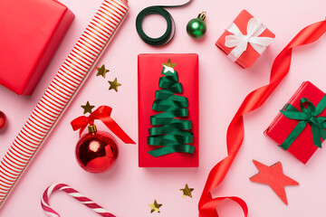 Wall Mural - Gift boxes with paper's rools and christmas decoration on color background, top view