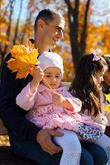 Poster - father and daughter are in an autumn city park, happy people posing together, playing with yellow leaves, beautiful nature, bright sunny day