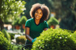 Young black female landscaper doing her job. Young woman gardener working in greenhouse.