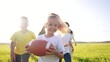 © maxximmm - children playing rugby in the park. a group of children play american football run outdoors in the park in summer. happy family kid dream concept. family children play american football run lifestyle