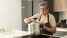 Mature Spanish woman closing a pressure cooker to cook cocido madrileño.