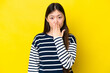 Young Chinese woman isolated on yellow background covering mouth with hand